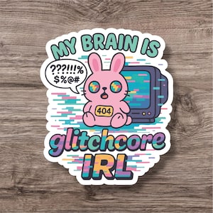 Puede incluir: Una pegatina con un conejito rosa con ojos de efecto glitch y una insignia "404", frente a un televisor retro. El texto incluye "MY BRAIN IS", una burbuja de diálogo con símbolos y "glitchcore IRL". El diseño tiene una estética digital colorida.