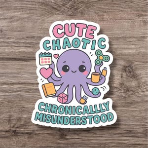 May include: A sticker featuring a cartoon octopus with the words "Cute Chaotic Chronically Misunderstood." The octopus is purple and holds various objects, including a calendar, heart, book, dice, and a fidget spinner.