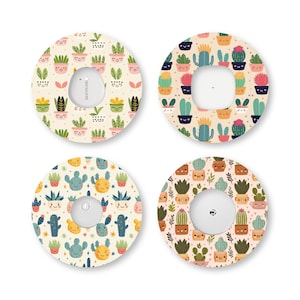 May include: Four circular adhesive patches for medical devices, each featuring a repeating pattern of colorful cartoon cacti with smiling faces. The designs include various shades of green, pink, yellow, and blue on cream and light pink backgrounds.