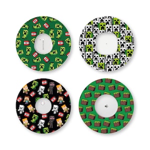 May include: Four circular adhesive patches for medical sensors, each featuring distinct patterns. One has green creepers and TNT, one has black and white creeper faces, one has various game characters on black, and one has a green grass block pattern.