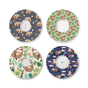 May include: Four circular adhesive patches for medical sensors, each featuring a unique sloth-themed pattern. Designs include sloths on branches with stars and moons, sloths in green foliage, sloths with tropical flowers, and sloths among clouds and moons.