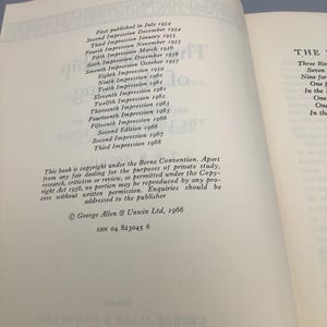 Puede incluir: P&aacute;ginas de libro abierto con texto que detalla la historia de la publicaci&oacute;n, incluyendo m&uacute;ltiples impresiones y ediciones de 1954 a 1968. Tambi&eacute;n se ve informaci&oacute;n de derechos de autor y detalles del editor. El libro est&aacute; abierto sobre una superficie azul.