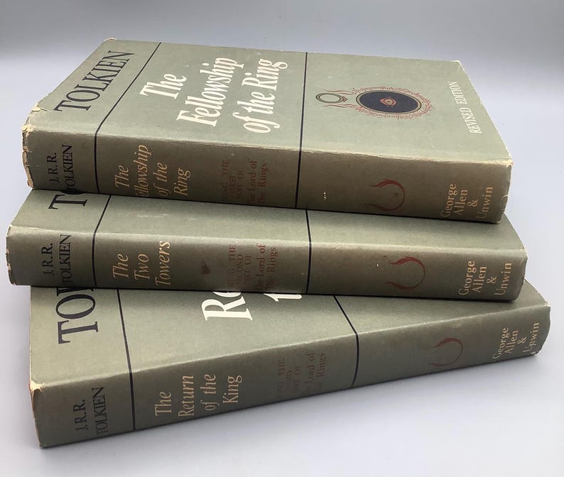 Puede incluir: Tres libros antiguos de J.R.R. Tolkien: "La Comunidad del Anillo", "Las Dos Torres" y "El Retorno del Rey". Los libros tienen una cubierta verde p&aacute;lido con t&iacute;tulos en blanco y rojo. T&iacute;tulos de la serie El Se&ntilde;or de los Anillos.