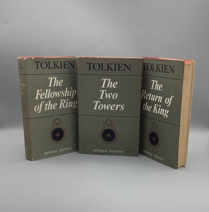 Puede incluir: Tres libros antiguos de J.R.R. Tolkien, con los t&iacute;tulos "La Comunidad del Anillo", "Las Dos Torres" y "El Retorno del Rey". Los libros tienen una cubierta verde con el nombre del autor y el t&iacute;tulo en blanco. Los libros son "Edici&oacute;n Revisada".