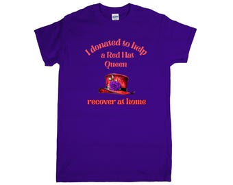 May include: A purple t-shirt with the text "I donated to help a Red Hat Queen recover at home." The shirt features an illustration of a red hat with a purple flower. The text and graphic are in orange.