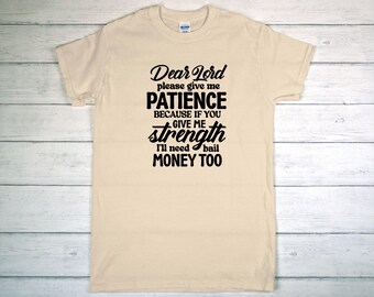 May include: Cream-colored t-shirt with black text. The text reads "Dear Lord please give me PATIENCE BECAUSE IF YOU GIVE ME strength I'll need bail MONEY TOO."