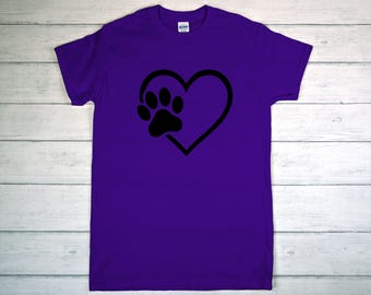 May include: A purple t-shirt featuring a black heart with a paw print inside. The shirt is made of a soft material and has short sleeves. The design is simple and eye-catching, perfect for pet lovers.