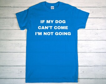 May include: Bright blue t-shirt with white text: "IF MY DOG CAN'T COME I'M NOT GOING." The shirt is made of a soft material and has a crew neck. The shirt is displayed on a light wood surface.
