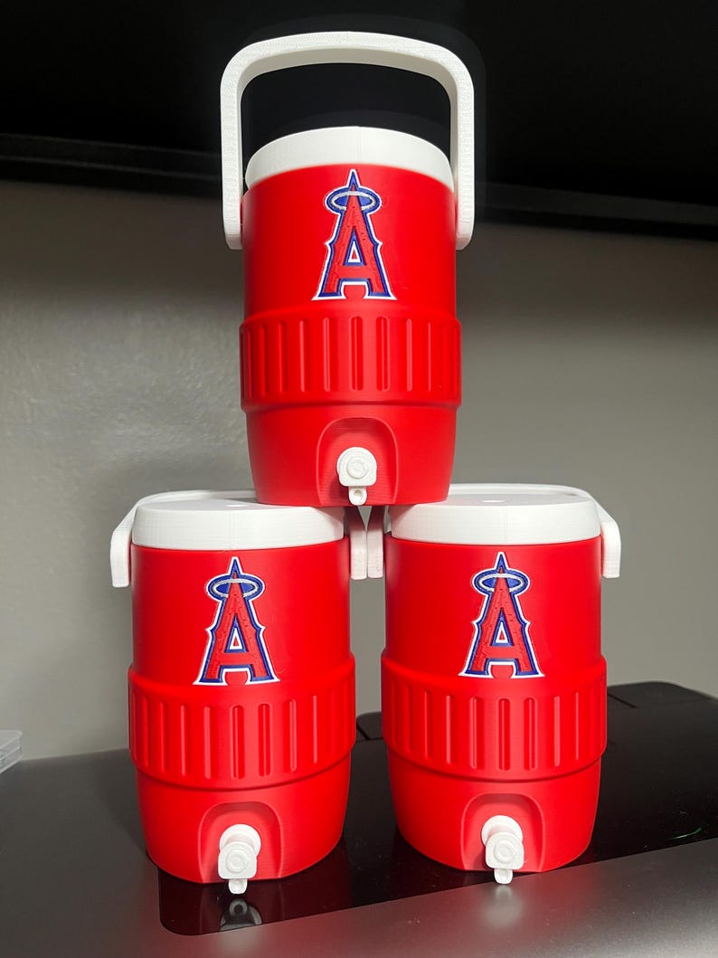 K&ouml;nnte beinhalten: Drei rote Wasserk&uuml;hler mit wei&szlig;en Deckeln und Griffen sind gestapelt. Jeder K&uuml;hler zeigt das Logo der Los Angeles Angels in Blau und Wei&szlig;. Die K&uuml;hler haben einen Wasserhahn zum Ausgeben von Fl&uuml;ssigkeiten.