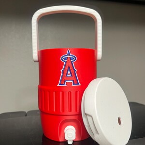 K&ouml;nnte beinhalten: Ein roter Wasserk&uuml;hler mit wei&szlig;em Griff und Deckel. Der K&uuml;hler hat das Logo der Los Angeles Angels in Blau und Wei&szlig;. Der Deckel ist zur Seite.