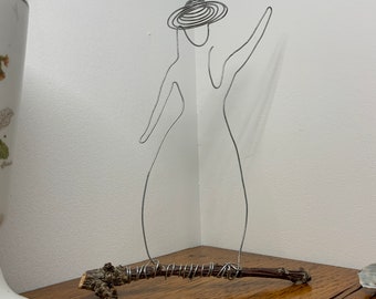 Un signe de la main, figé dans ses courbes par Anouk, fil de fer
