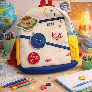 May include: A set of three ceramic mugs with a speckled, matte finish. The mugs are in shades of cream, light gray, and dark gray. Each mug has a simple, minimalist design and a rounded handle. The mugs are likely for coffee or tea.