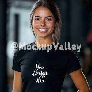 May include: A woman wearing a black t-shirt with the text "Your Design Here" printed on the front. The woman is smiling and looking at the camera.