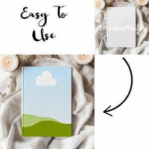 May include: A white notebook with a blue sky and green hills design on the cover. The notebook is lying on a white fabric surface with dried flowers and candles.