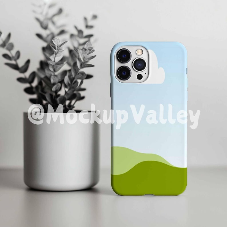 May include: A white iPhone case with a blue sky and green hills design. The case has a cutout for the camera lens.