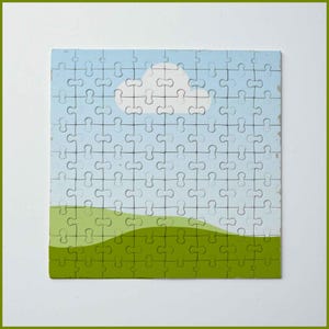 Pode incluir: Um quebra-cabe&ccedil;a completo com uma cena de paisagem. O quebra-cabe&ccedil;a mostra um c&eacute;u azul com uma nuvem branca, colinas verdes e um fundo azul claro. O quebra-cabe&ccedil;a &eacute; quadrado e tem uma borda branca.