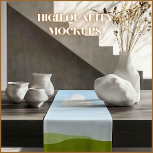 May include: A light blue table runner with a green and white landscape design. The runner is on a wooden table with white ceramic pots and a white rock.