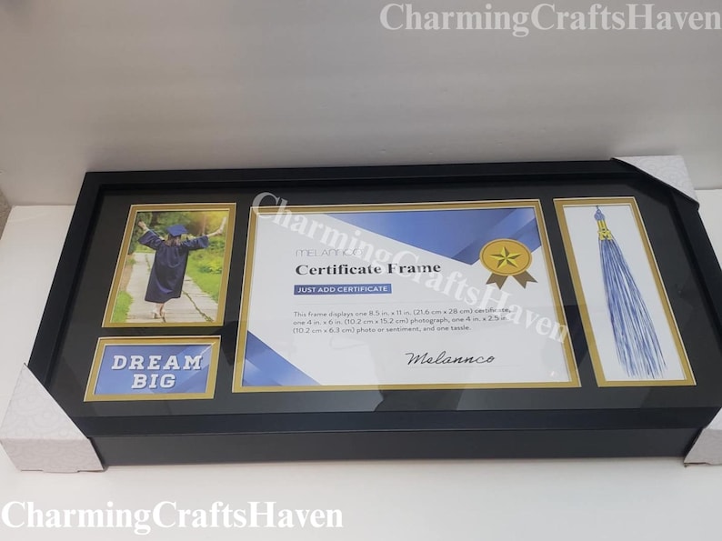May include: Black certificate frame with gold trim, holding a graduation photo, certificate, and tassel. The frame includes the text "DREAM BIG" and "Certificate Frame". The frame displays an 8.5 in x 11 in certificate, a 4 in x 6 in photo, and a tassel.