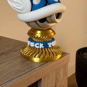 Mario Kart inspirierter blauer geflügelter Muschelständer