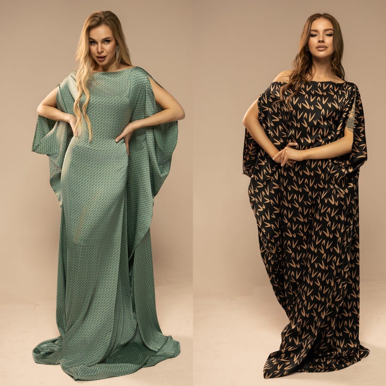 May include: Two women wearing long, flowing dresses with different patterns. The dress on the left is a teal green with a geometric pattern, while the dress on the right is black with a brown pattern of stylised Vs.