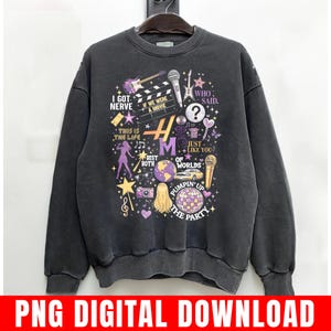 Pode incluir: Camisola cinza escuro com um design gr&aacute;fico com instrumentos musicais, uma claquete de filme e o texto "I Got Nerve", "If We Were a Movie" e "Pumpin' Up The Party". O design inclui detalhes em roxo e dourado.