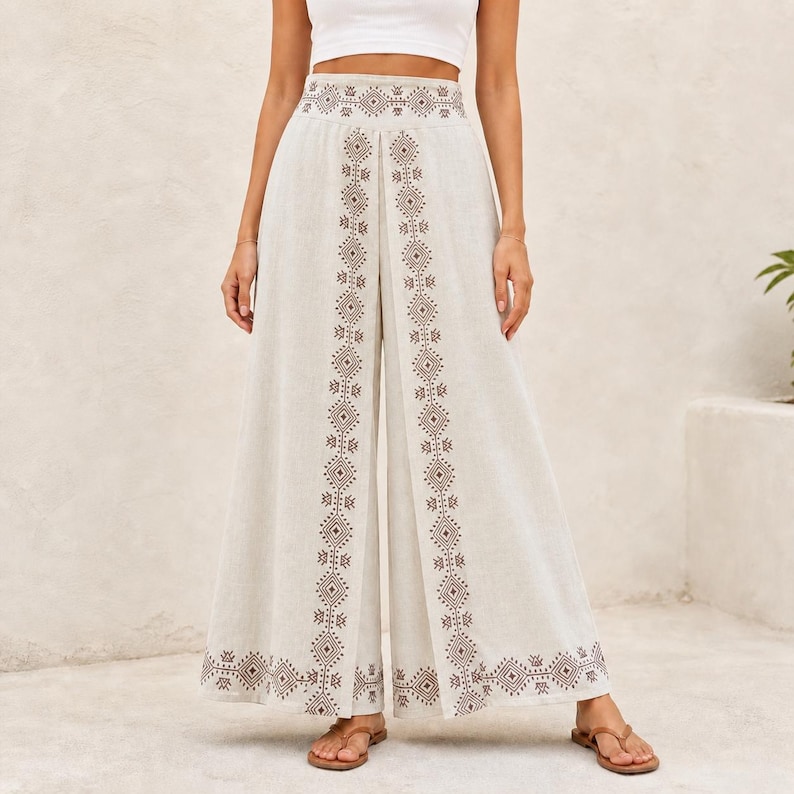 May include: Off-white palazzo pants with a geometric embroidered design in brown. The wide-leg pants feature a high waist and are suitable for casual wear. The pants are made of a lightweight fabric.