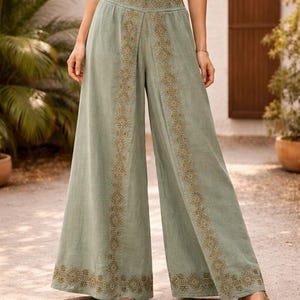 May include: Sage green palazzo pants with intricate embroidered detailing in a geometric pattern. The wide-leg pants feature a high waist and are made of a lightweight fabric. The pants are a stylish choice for casual wear.