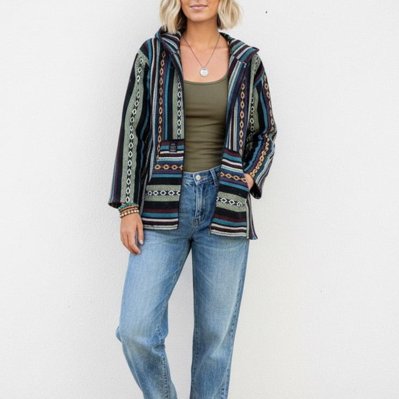 May include: A hooded jacket with a striped pattern in shades of black, teal, and burgundy. The jacket has a front zipper and two pockets. The person is wearing a green tank top and blue jeans. The jacket is a casual, bohemian style.