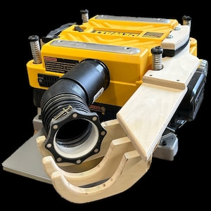 May include: A yellow and black power planer with a dust collection hose attached to a custom-made wooden dust collection system. The system has two wooden arms that extend out from the planer and connect to the hose.