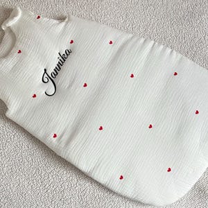 May include: A white ceramic mug with a black handle and the text "But First, Coffee" in a handwritten style. The mug is on a white surface. The mug is 10 cm tall.