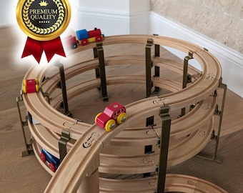 Może przedstawiać: Wielopoziomowy drewniany zestaw torów kolejowych ułożony w spiralę z ciemnymi metalowymi wspornikami. Zestaw zawiera małe drewniane samochodziki i lokomotywę w kolorach czerwonym, niebieskim i żółtym. Złota odznaka zawiera napis PREMIUM QUALITY.