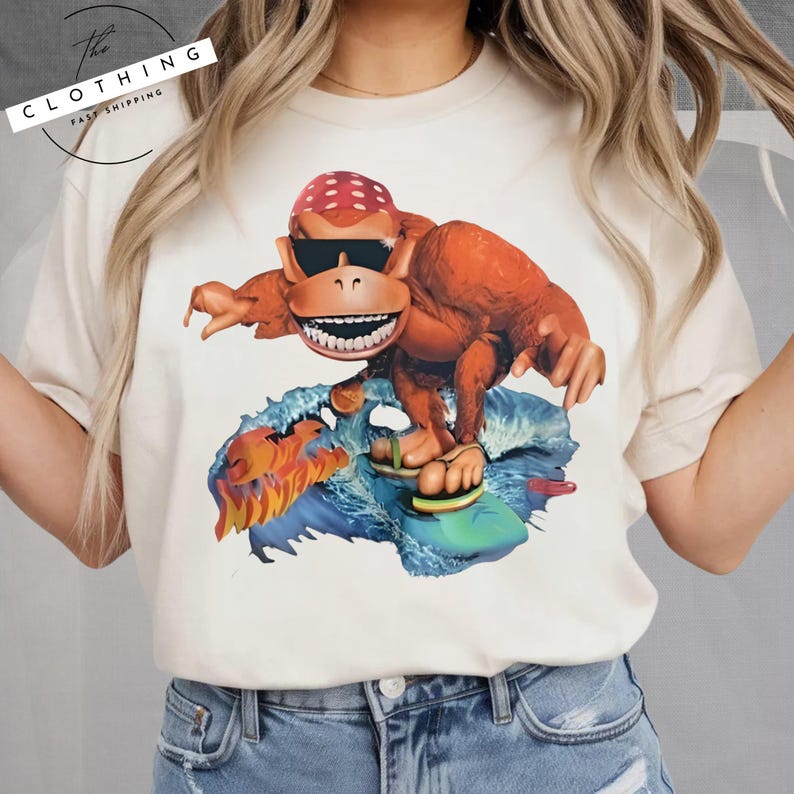 a woman wearing a t - shirt with a picture of a monkey riding a surf