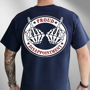 May include: A navy blue t-shirt with a white graphic on the back. The graphic shows two skeleton hands giving the middle finger, within a white circle with the words "PROUD" and "DISAPPOINTMENT" in red and white.