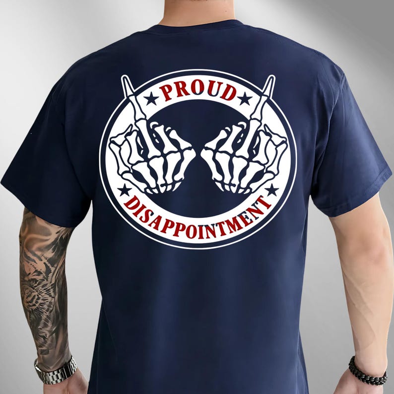 May include: A navy blue t-shirt with a white graphic on the back. The graphic shows two skeleton hands giving the middle finger, within a white circle with the words "PROUD" and "DISAPPOINTMENT" in red and white.