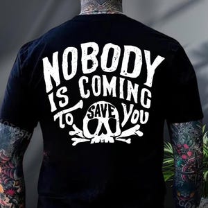 the back of a person wearing a black t-shirt with white text and a skull graphic.