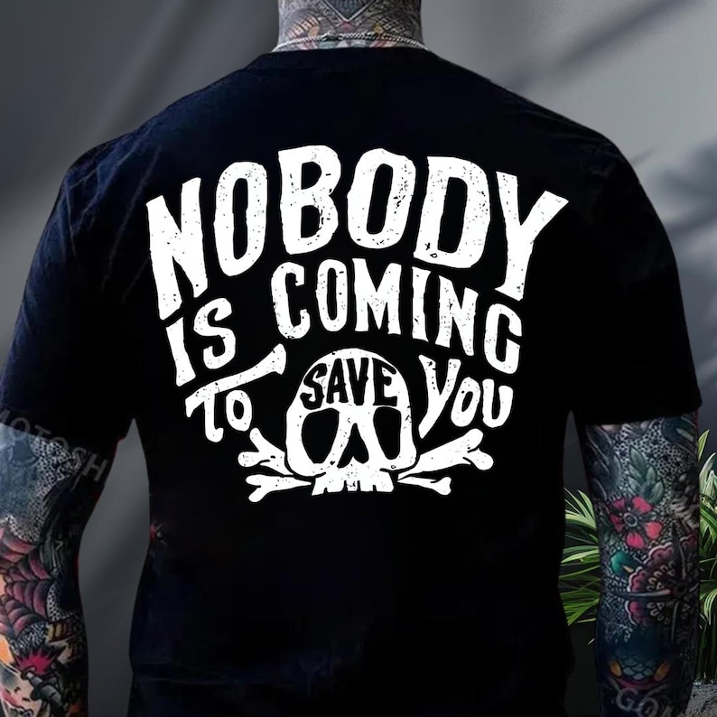 the back of a person wearing a black t-shirt with white text and a skull graphic.