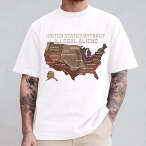 May include: White t-shirt featuring a map of the United States with the text "UNITED STATES WITHOUT ILLEGAL ALIENS." The map is colored in shades of brown and tan, with various tribal names. The shirt has short sleeves and a crew neck.