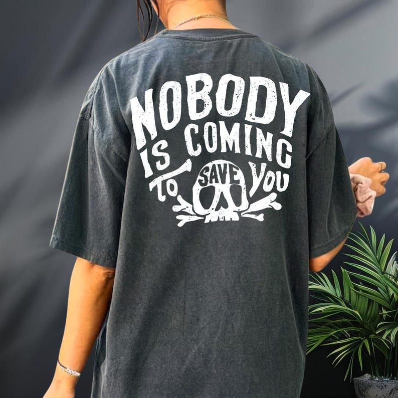 a person wearing a black t-shirt with white text and graphics printed on the back.