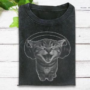 May include: Dark gray t-shirt featuring a graphic of a cat wearing headphones. The cat image is created with a dotted pattern. The shirt has a crew neck and short sleeves. The fabric appears to be pre-washed for a vintage look.