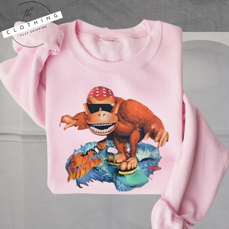 a pink shirt with a picture of a dinosaur on it