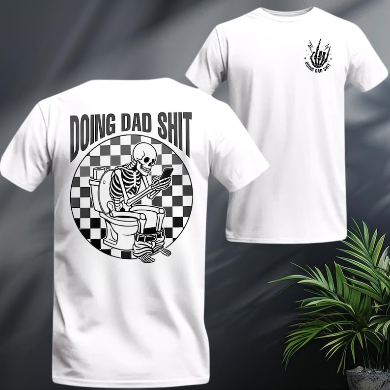 May include: White t-shirt with a black and white graphic of a skeleton on a toilet, looking at a phone. The text "DOING DAD SHIT" is above the graphic. A smaller graphic of a hand gesture and text "DOING DAD SHIT" is on the front.