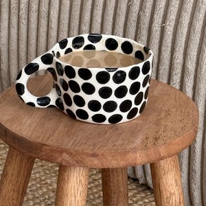 Caneca de café de cerâmica artesanal – Xícara de cerâmica com bolinhas pretas, design estético.