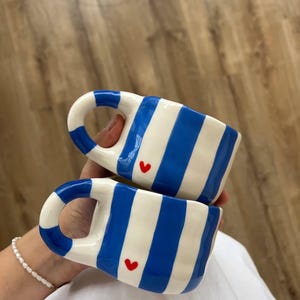 手描きの陶器製コーヒーマグ：白地に青いストライプと赤いハート
