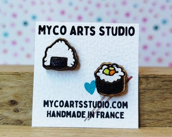 Könnte beinhalten: Ein Paar Holzohrringe mit einem Sushi-Roll und einem Onigiri. Die Ohrringe sind handgefertigt in Frankreich und werden von Myco Arts Studio verkauft.