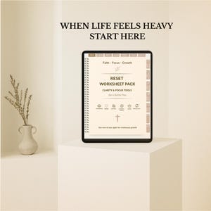 May include: A digital worksheet pack titled "RESET WORKSHEET PACK" with the text "CLARITY & FOCUS TOOLS for a Better You." The image also includes the text "WHEN LIFE FEELS HEAVY START HERE." The worksheet is on a white stand with a small vase and plant.