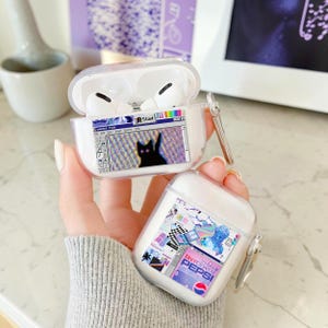 May include: Two clear plastic protective cases for wireless earbuds. One case is open, revealing white earbuds and a graphic of a computer paint program with a black cat. The other case features a collage of retro digital stickers including Diet Pepsi.