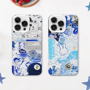 Op de afbeelding: Twee transparante telefoonhoesjes met blauwe en witte ontwerpen. Het linker hoesje heeft een blauw en wit ontwerp met een hart, dobbelstenen en een poolbal. Het rechter hoesje heeft een blauw en wit ontwerp met een konijn, sterren en wolken. Beide hoesjes hebben de tekst "COOKIE 2" erop.