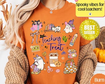 May include: Burn orange t-shirt with a colorful graphic design featuring ghosts, books, and the text "Teaching is a Treat." The shirt also includes the text "Spooky vibes for cool teachers!" and a "Best Seller" sticker.