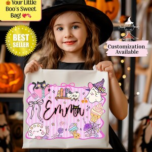 Peut inclure: Un sac fourre-tout blanc sur le th&egrave;me d'Halloween avec un motif rose et violet. Le sac pr&eacute;sente un chat de dessin anim&eacute;, un fant&ocirc;me et un cornet de cr&egrave;me glac&eacute;e. Le nom "Emma" est &eacute;crit en cursive. Le texte sur le sac indique "Your Little Boo's Sweet Bag!" et "Best Seller".