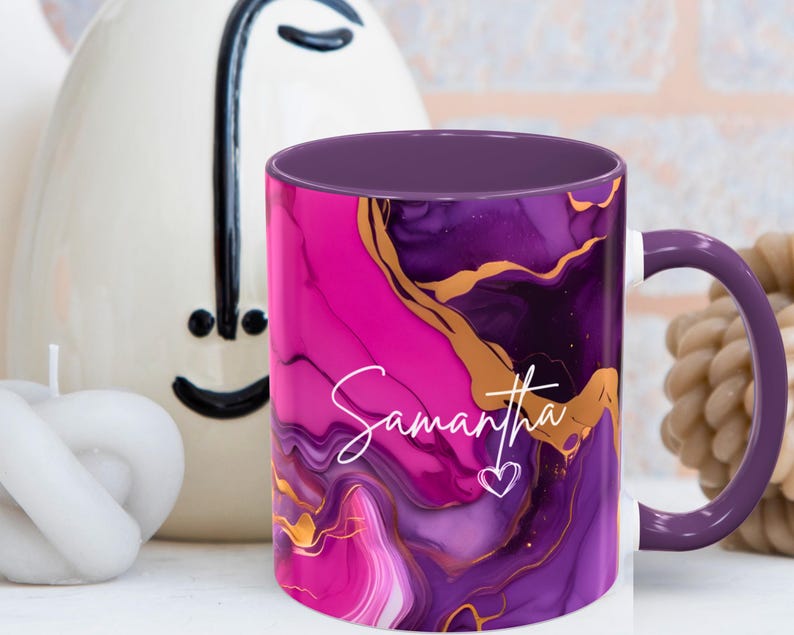 Pode incluir: Caneca de caf&eacute; roxa e rosa com um design de redemoinho dourado e o nome Samantha escrito em branco. A caneca tem um interior roxo.
